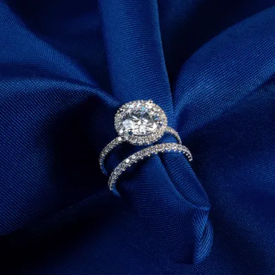 Two diamond promise rings in white gold setting, displayed on a blue background