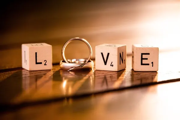 scrabble letters spelling out love with wedding ring in the middle for the "o"