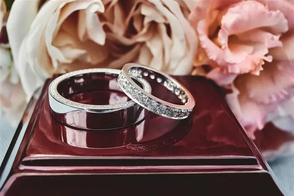Groom and brides diamond wedding bands placed on top of each other