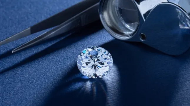 A diamond beside a loupe and tweezers, set against a blue background
