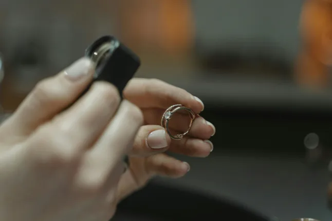 Jeweler closely examining a diamond ring for signs of damage or needed repairs