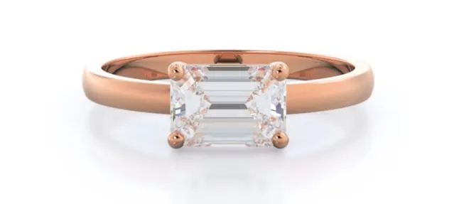 Horizontal emerald cut diamond set in rose gold solitaire setting
