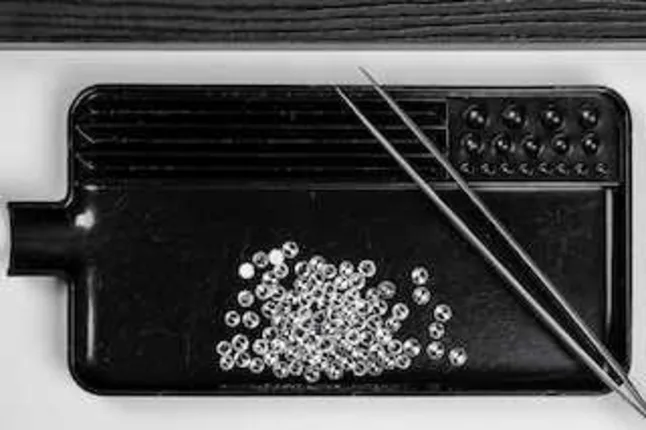black sorting tray holding loose diamonds