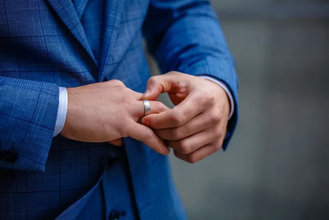 Man in a blue suit with a wedding band on