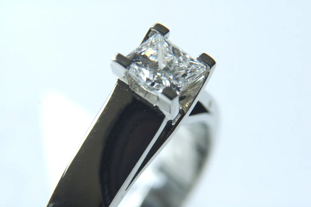 Close up of a solitaire diamond ring on a silver band