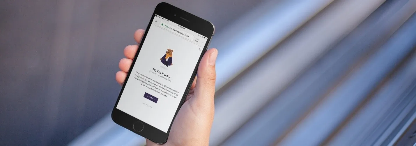 Close-up of a hand holding a smartphone displaying Rare Carat's chatbot page on the screen