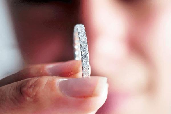 Close-up of a woman holding a diamond wedding band