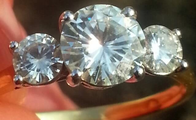 image of a moissanite ring with three round brilliant stones