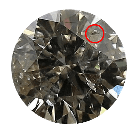 Image of a brown tinted diamond with a large cavity circled in red