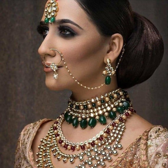 An Indian bride wearing Polki diamond jewelry in traditional Indian designs, with the polished side of the diamonds set forward to create a regal vibe