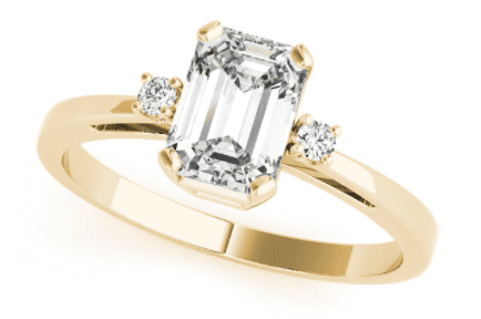 A three stone emerald engagement ring in yellow gold setting