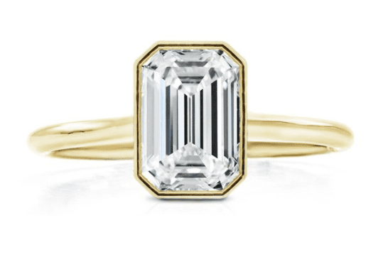 Emerald cut diamond set in a yellow gold bezel setting