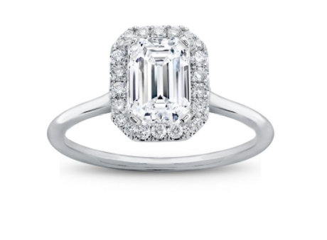 An emerald cut diamond ring with a halo in white metal