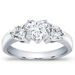 A three-stone diamond ring featuring a heart-cut diamond at the center