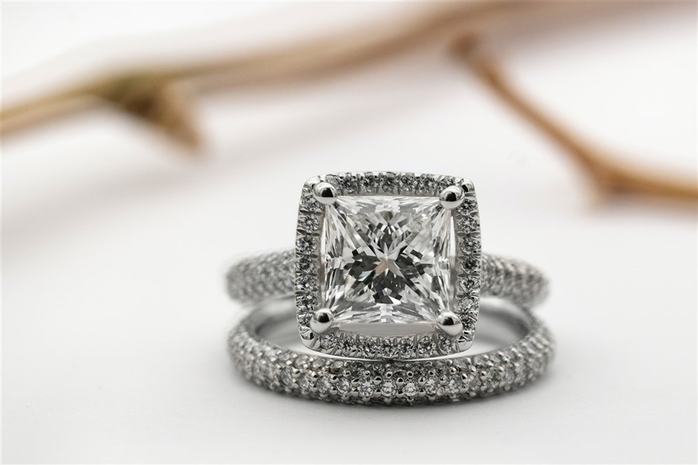 A diamond engagement ring set displayed on a soft-focus white background