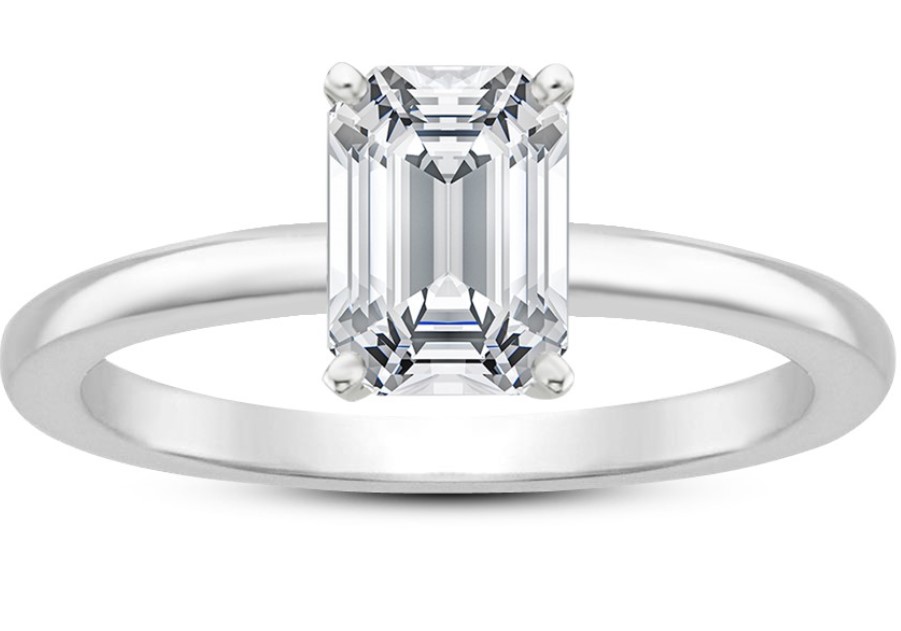 An emerald solitaire diamond ring