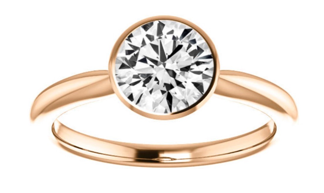 A round diamond in a rose gold bezel set solitaire ring