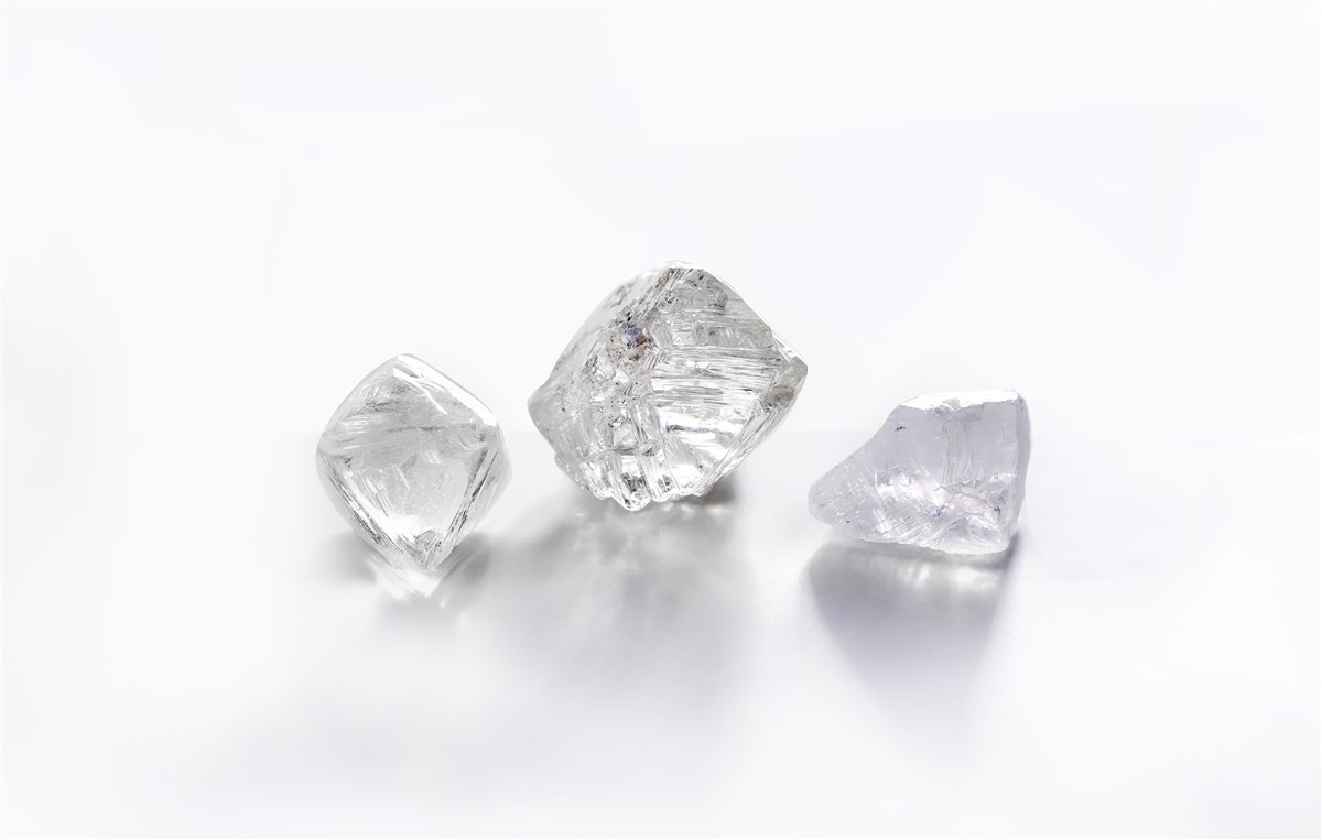 Three rough diamonds displayed against a white surface