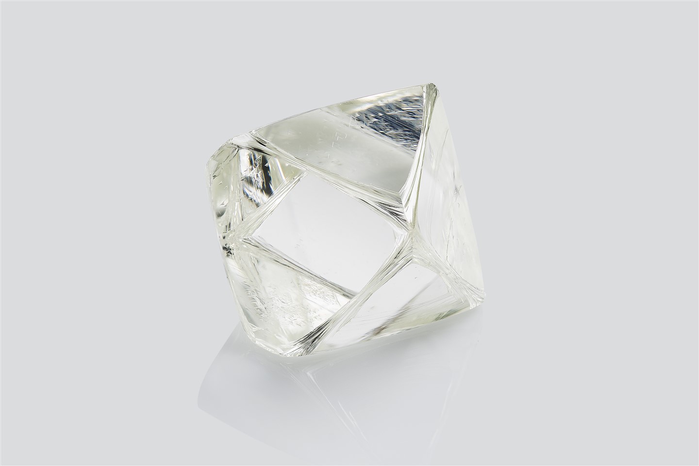 A rough diamond displayed on a white surface