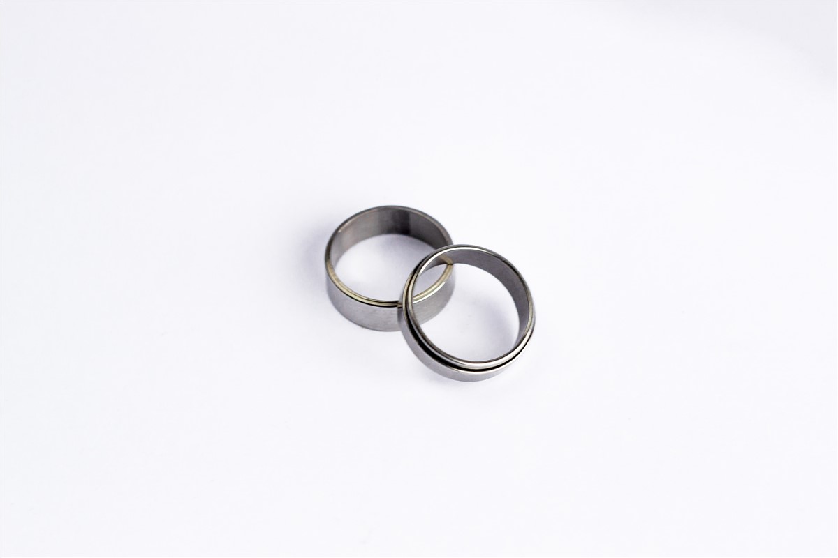 A pair of simple band rings resting on a white table