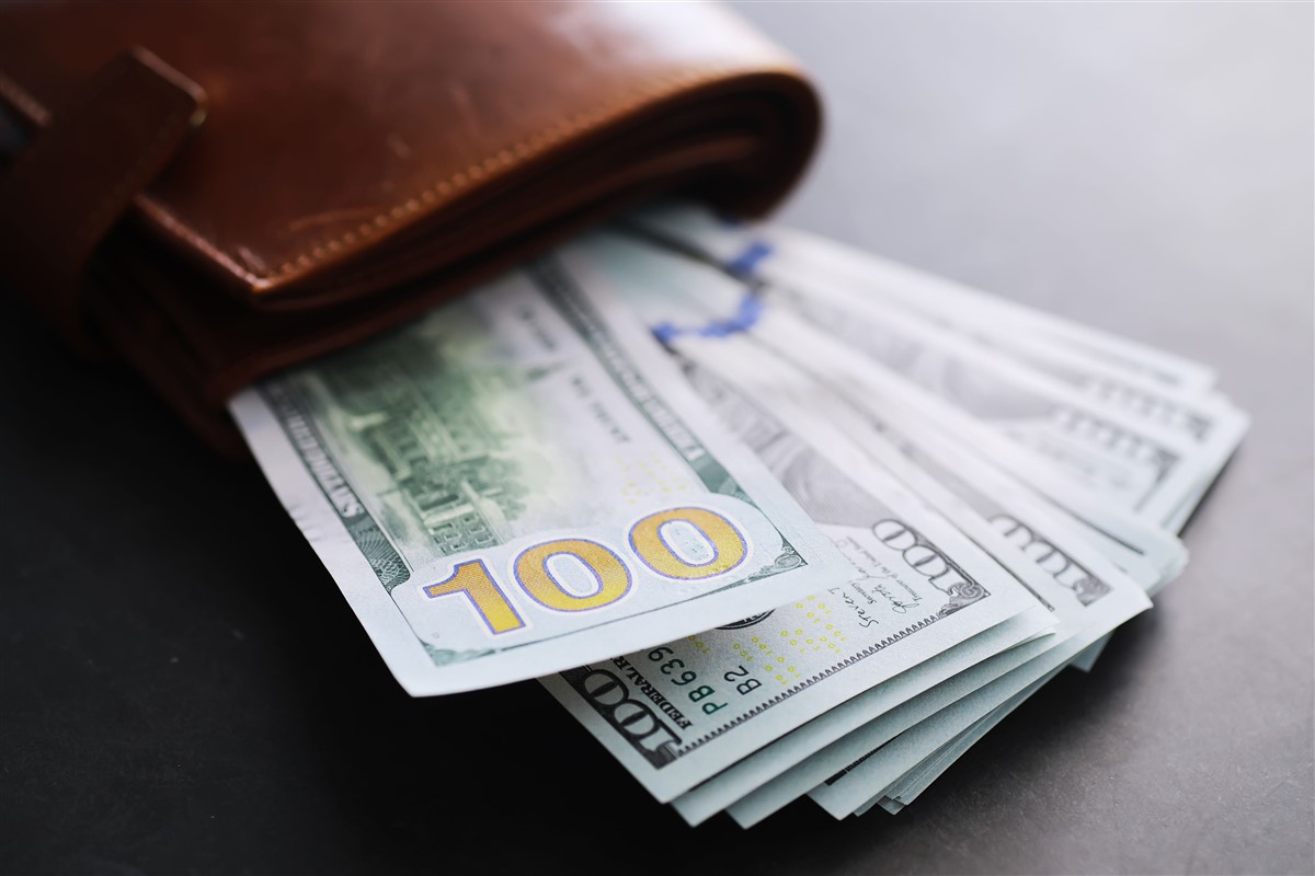 A wallet with 100 dollar bills sticking out