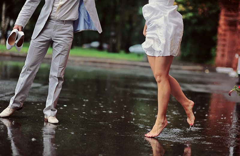 A close-up of a couple's legs dancing in the rain