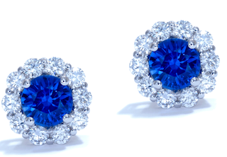 A pair of sapphire and diamond cluster earrings, set against a white background