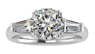 A three-stone engagement ring featuring a round center diamond and two tapered baguette diamonds