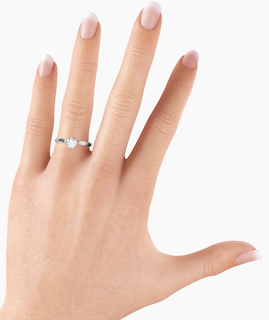 A half carat diamond ring on a woman's ring finger