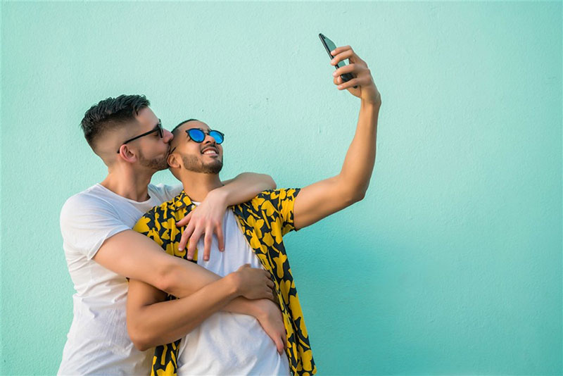 a same-sex couple taking selfie together