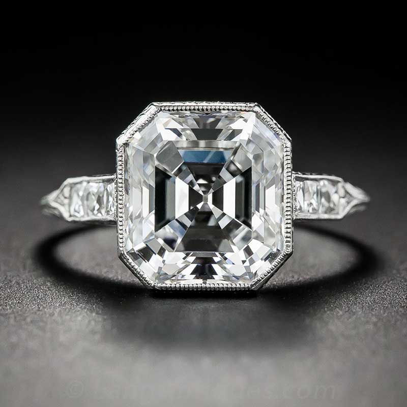 An asscher cut diamond engagement ring in a platinum setting, set against a black background